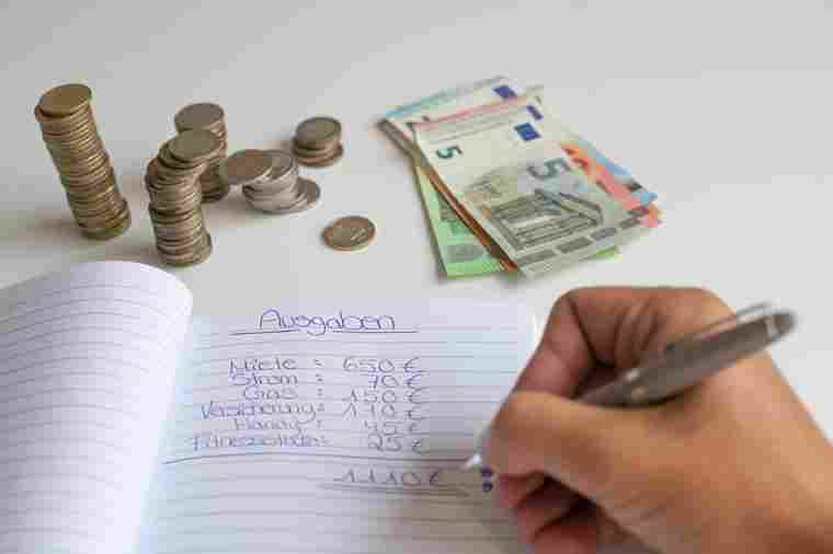 Person schreibt in Haushaltsbuch