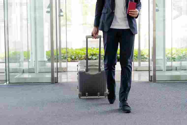 Mann mit Koffer am Flughafen